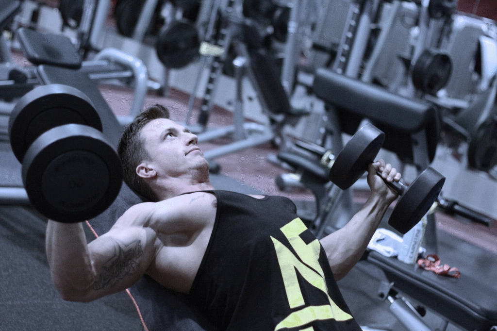 Lifter performing an intense incline dumbbell press with controlled form, demonstrating Mike Mentzer workout high-intensity training principles.