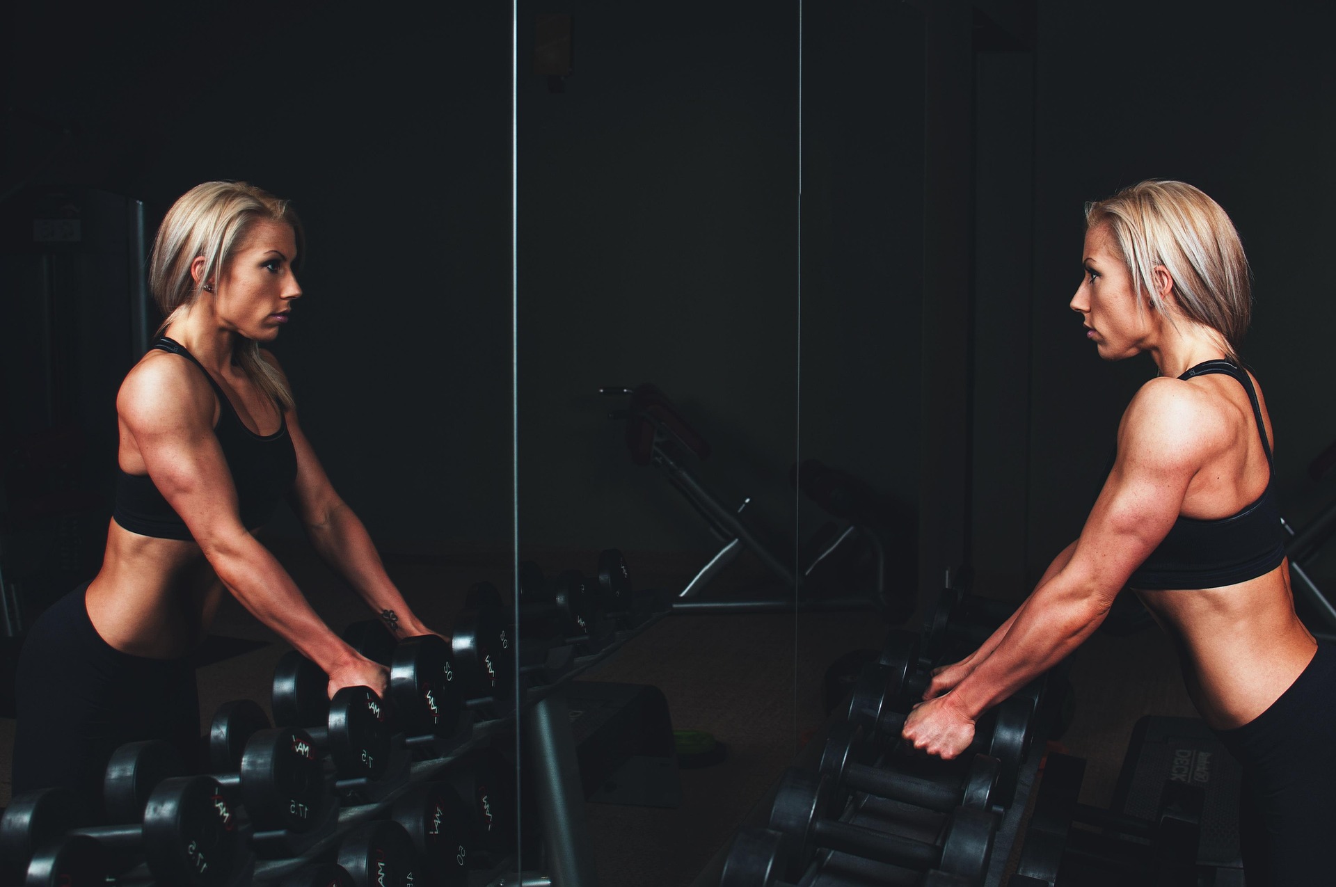 A focused woman reflecting on her workout in the mirror, symbolizing the confidence gained and the fear overcome after learning how to start going to the gym.